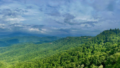 Panoramic view of sky, green trees, and Blue Ridge mountains