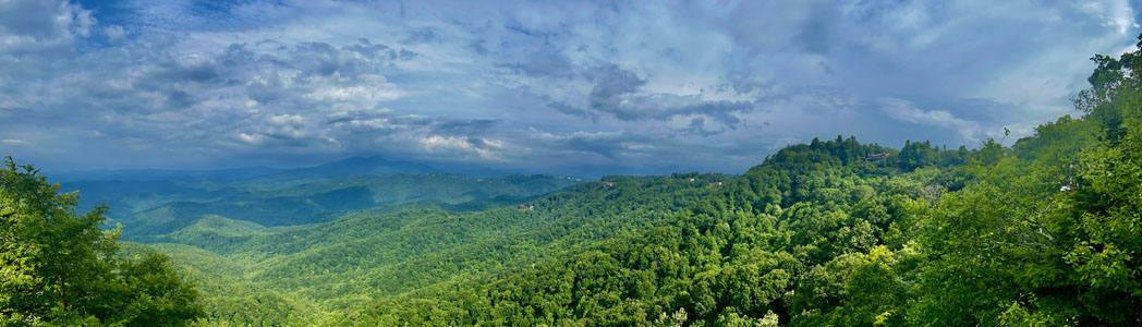 Panoramic view of sky, green trees, and Blue Ridge mountains