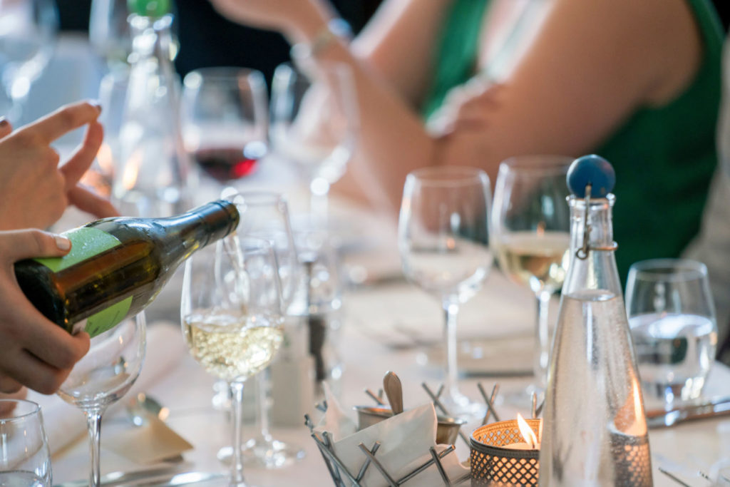 White wine being poured from a wine bottle into a wine glass