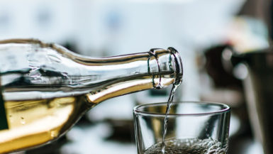 White wine being poured from a bottle into a glass